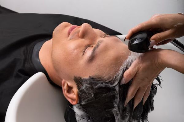 a man at the hairdresser's shampooing his hair