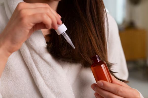 woman holding a hair oil