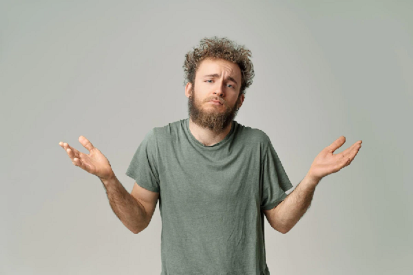 a curly-haired man with his hands at his sides showing resignation