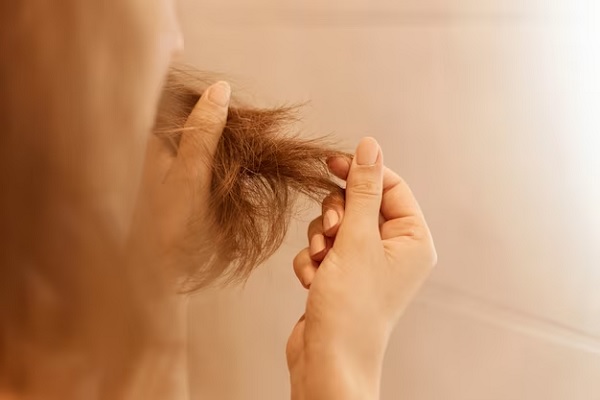 a woman looking at her non hydrated and dry hair