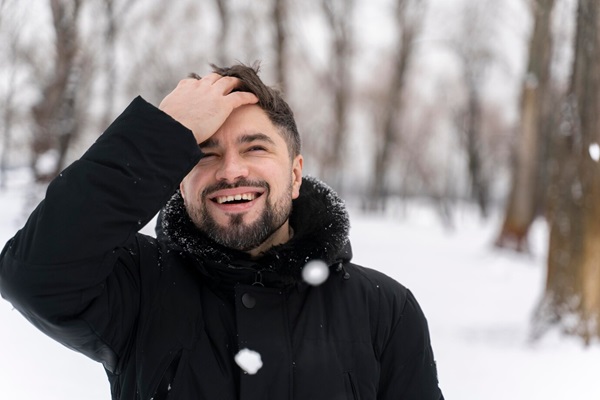 Near happy adult playing in the snow.