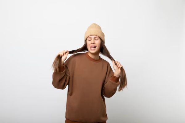 woman in cap shows her long hair