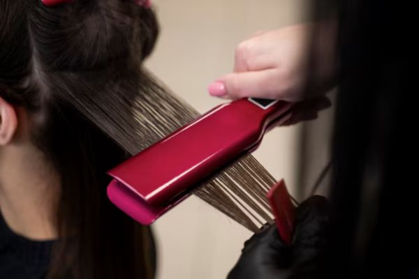 Straightening hair with a flat iron
