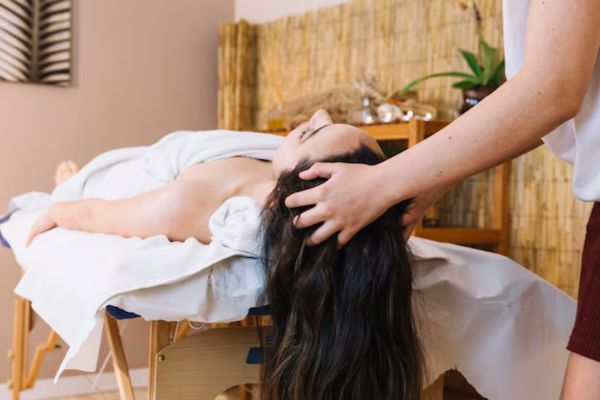 a woman and hairdresser performing a Hair Relaxation Treatment