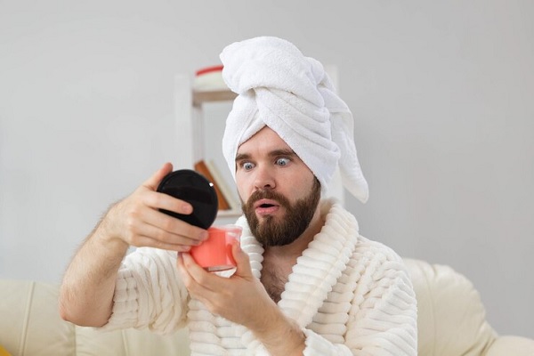 Handsome man with pink cosmetic hair scrub for spa skin and hair care for man concept