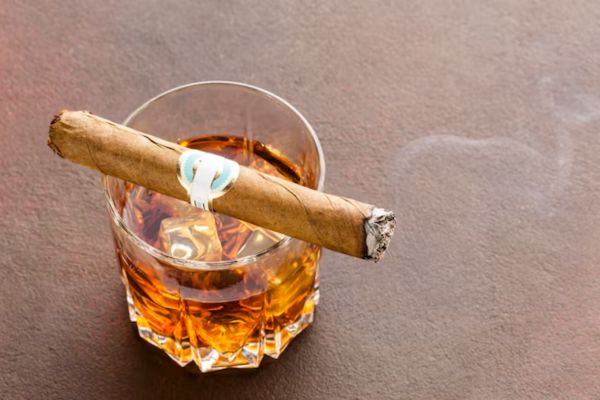 an image from above of a glass of alcohol and tobacco