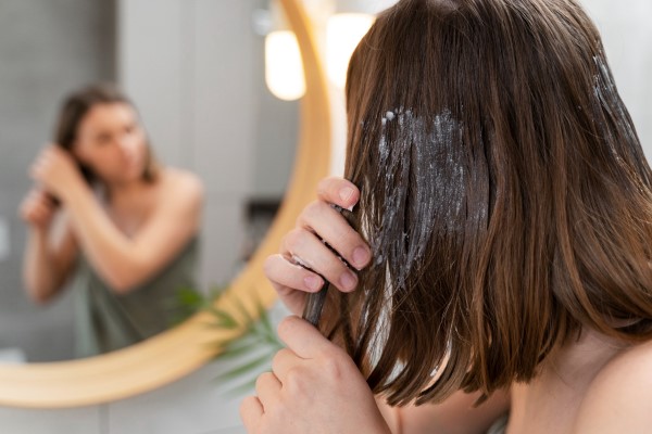 a woman puts minoxidil in her hair
