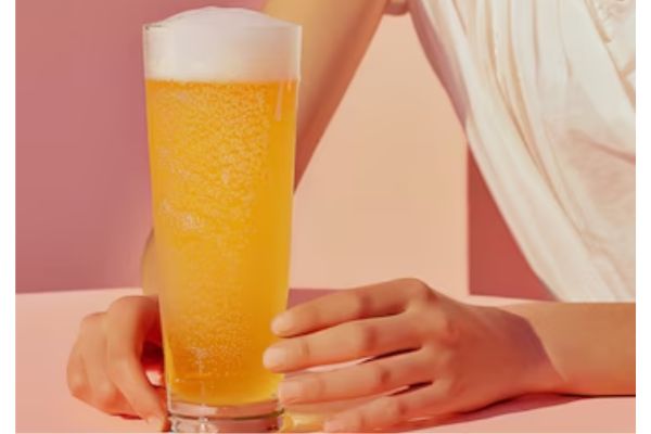 a woman holding a glass of beer for hair