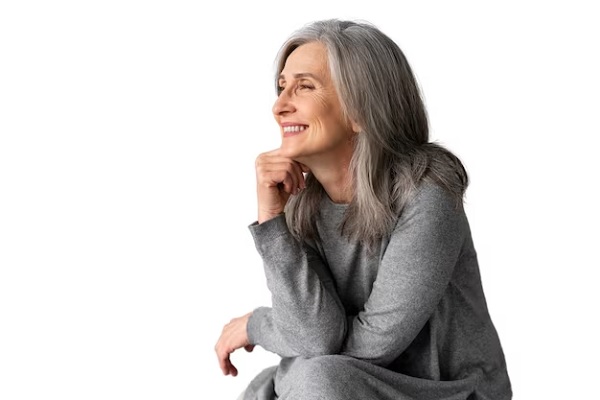 a smiley middle-aged lady going through menopause with grey hair