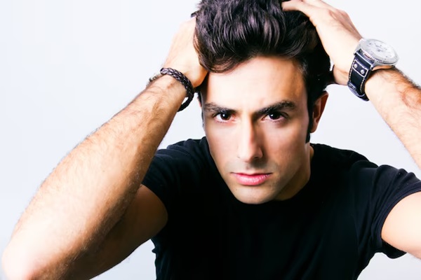 Portrait of young man holding his hair